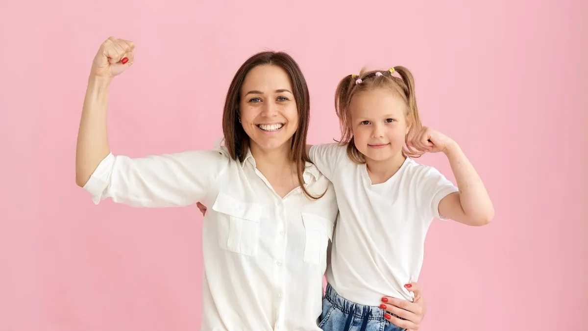 a mom and a child holding up their fists in front of a pink background