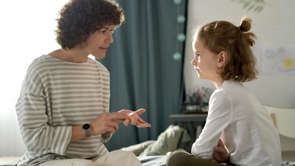 a person talking to a child on a bed