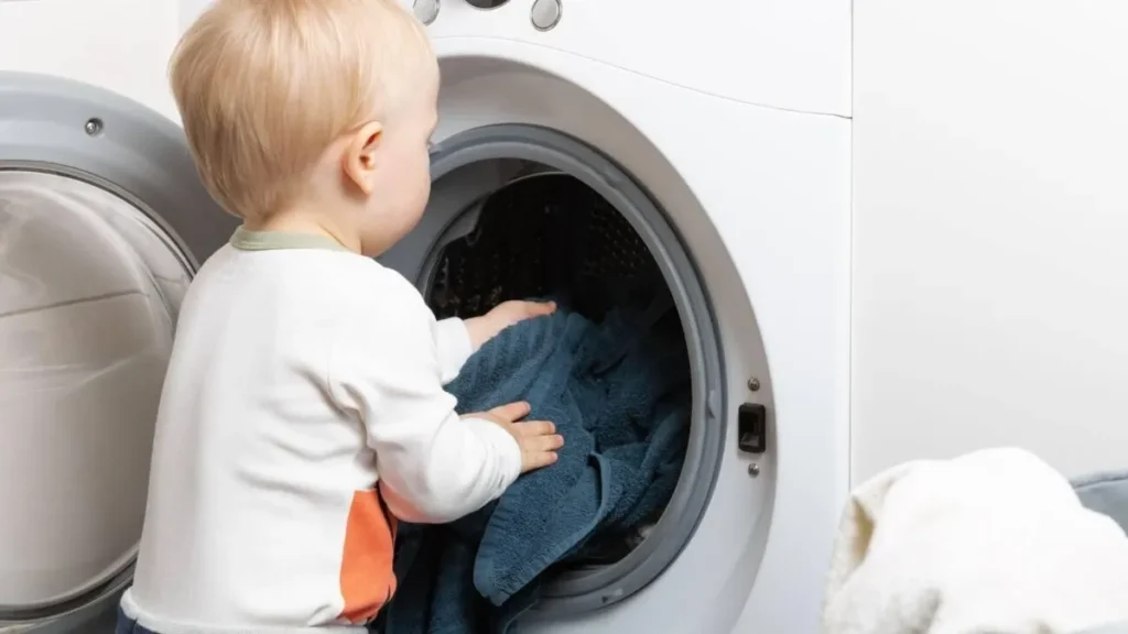 a toddler standing in front of a washing machine